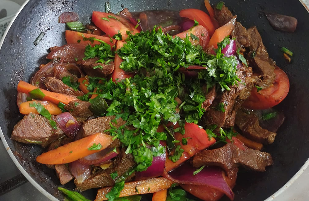 Carne salteada com coentro picado e legumes al dente